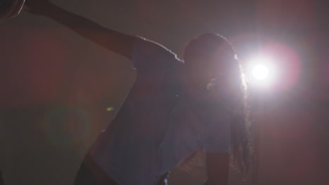 Backlit-Studio-Shot-Of-Young-Woman-Dancer-Being-Filmed-Dancing-In-Front-Of-Spotlight-1